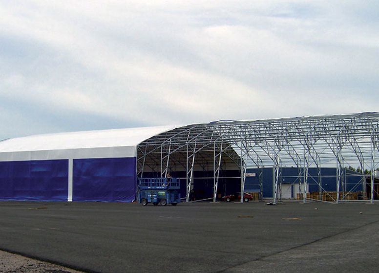 The roof covering of the steel-frame hall is spread out and finally tightened.